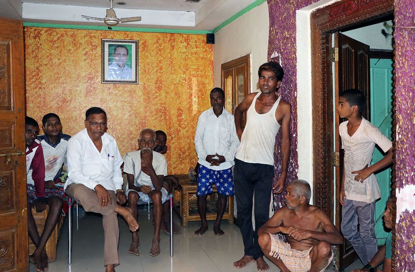 Group of men in a room. Gopal Dattu Kevari – one in a white vest