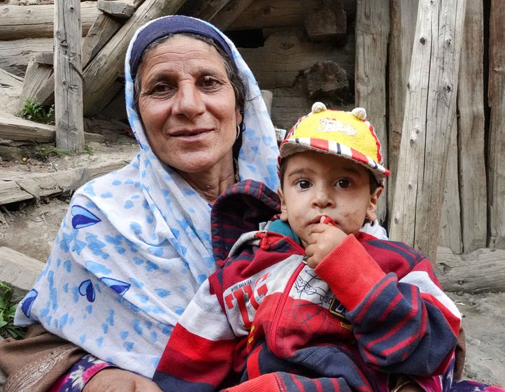 Jani Begum, the only midwife in the village, has delivered most of her grand-children. She sits in the sun with her grandchild Farhaz