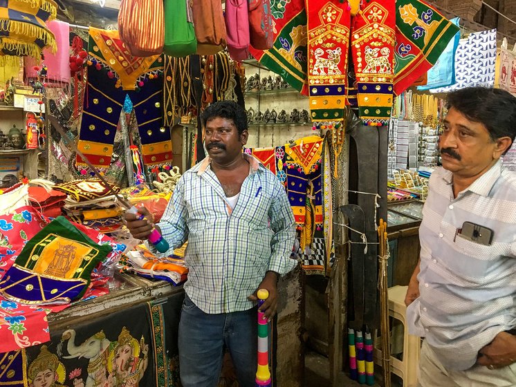 Siddique with his employee selvam who he refers to as nephew. Selvam is showing a sickle, various sizes of which can also be seen in the photo