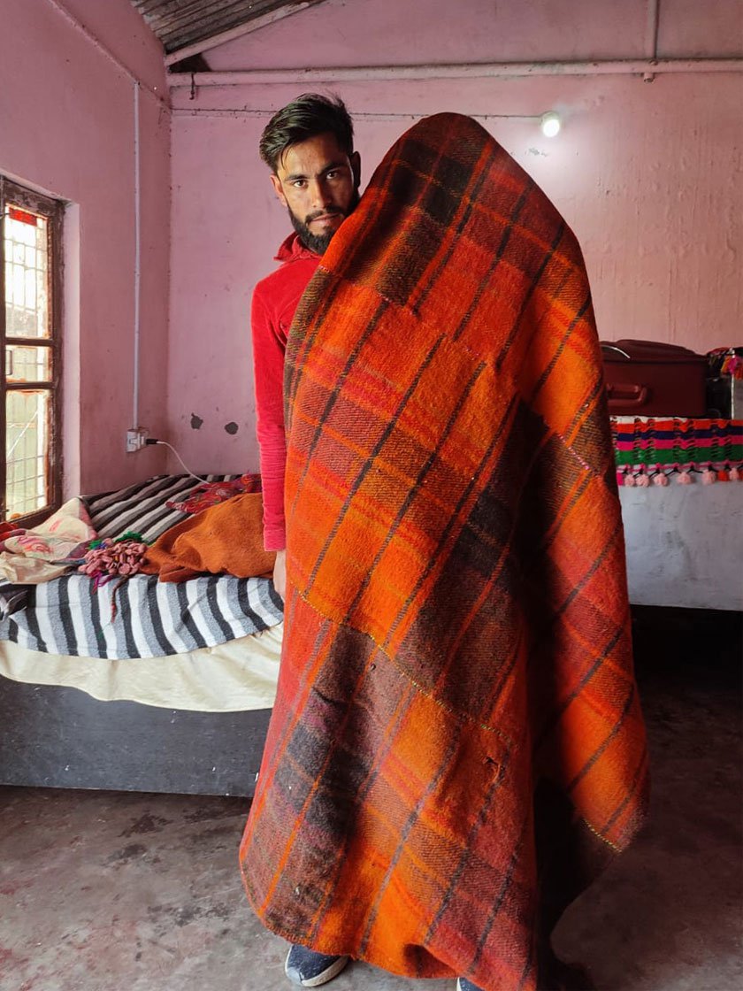 Right: Maaz Khan’s grandson Khalil shows the blanket that the family has made