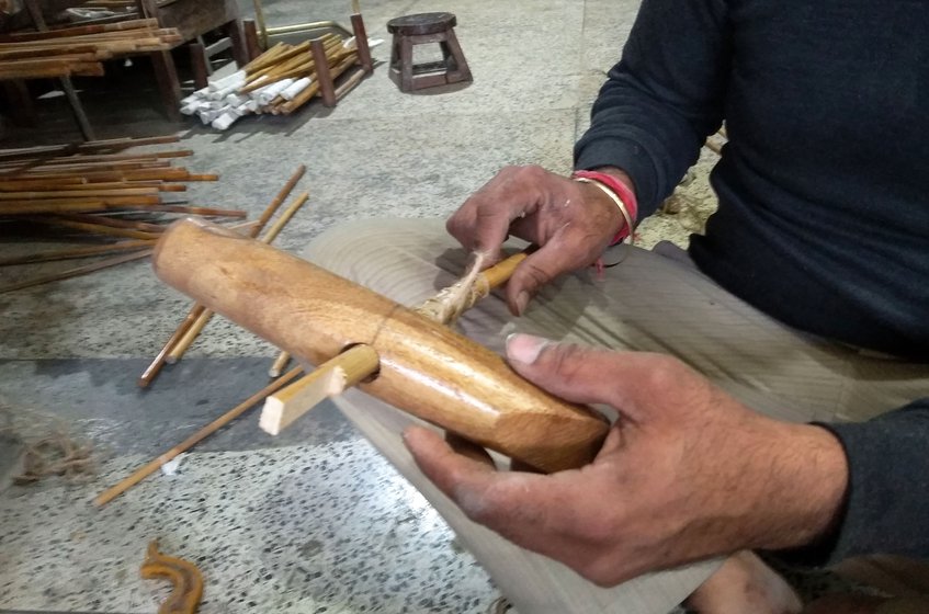 He makes a small slit at the end of this shaft and then places it through the mallet’s head.