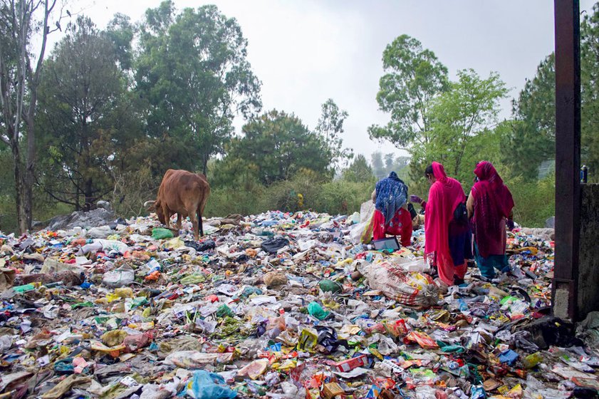 Right: Women waste workers sorting through trash for recyclable items