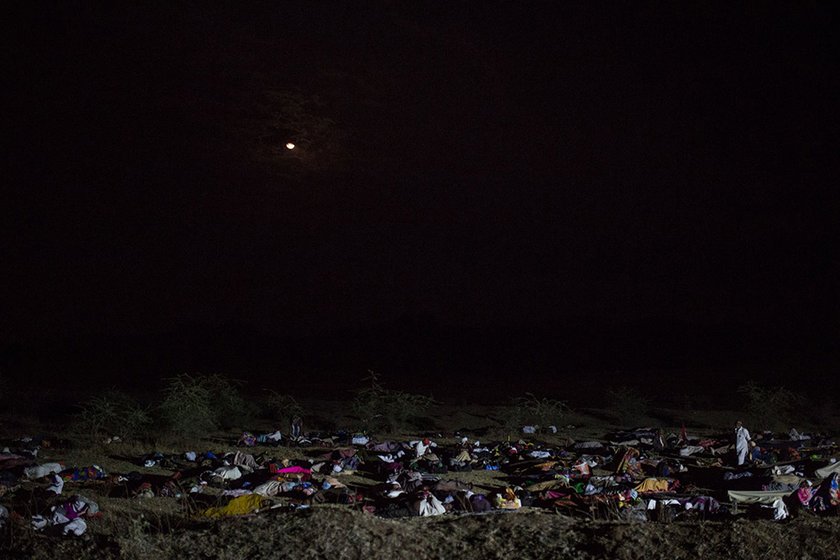 People sleeping in an open field at night