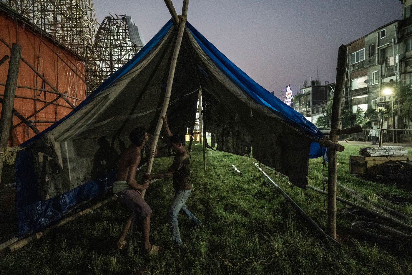 Jagga Ansari (right) sets up the tent right behind the puja pandal. This is where the group lives during the mela