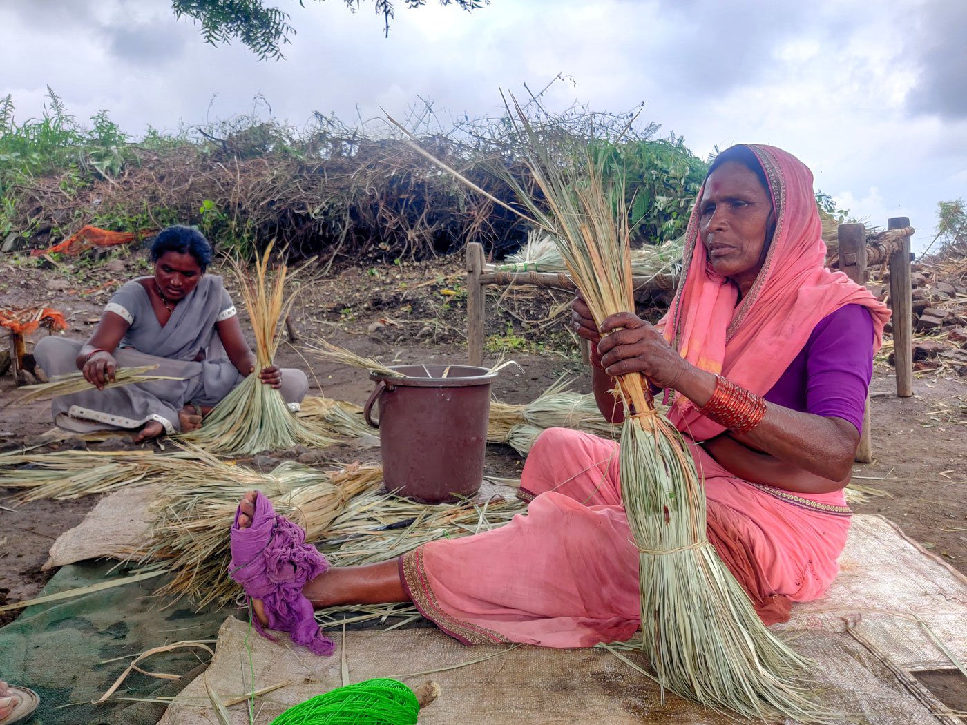 Kantabai Bhutadmal (in pink saree) binds brooms despite her weak eyesight. Her family depends on the income she earns from selling them