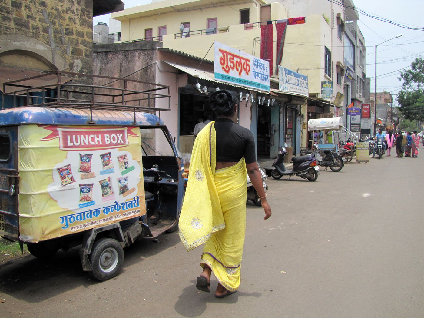 Radhika Gosavi walking through the market street on a very sunny afternoon