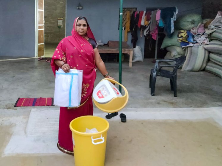 An ASHA worker in Chitrakoot, Chunki Devi, at her home with the dustbin, sanitisers and PPE kits she had to carry to the polling booth