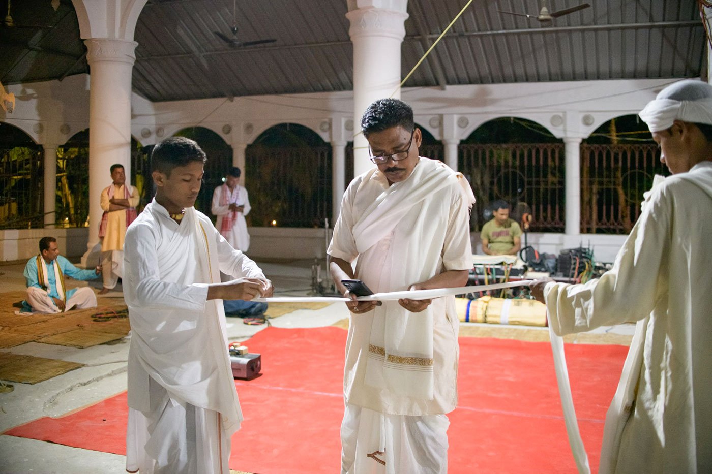Tulasi Borah (centre) and Priyabrat (right) help Jyotishman Dutta roll his paag in the namghar (prayer house) of the Garamur Saru Satra