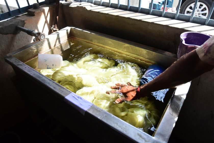 A worker soaking the yarn in water before dyeing it. 