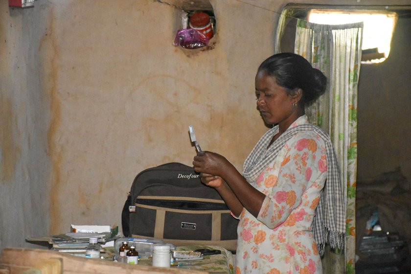 Jyoti preparing an injection to be given to a patient inside her work area at home.