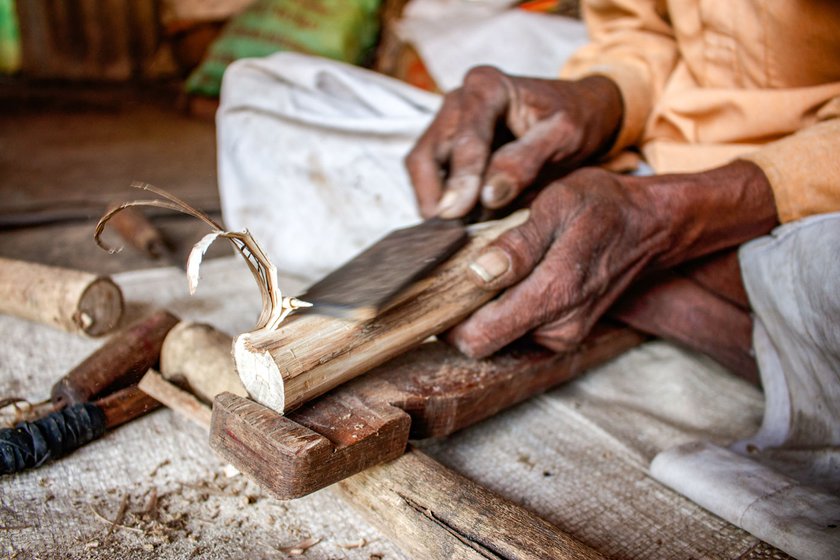 Left: After cutting a wood log, Narayan chisels the wooden surface and shapes it into a conical reed.