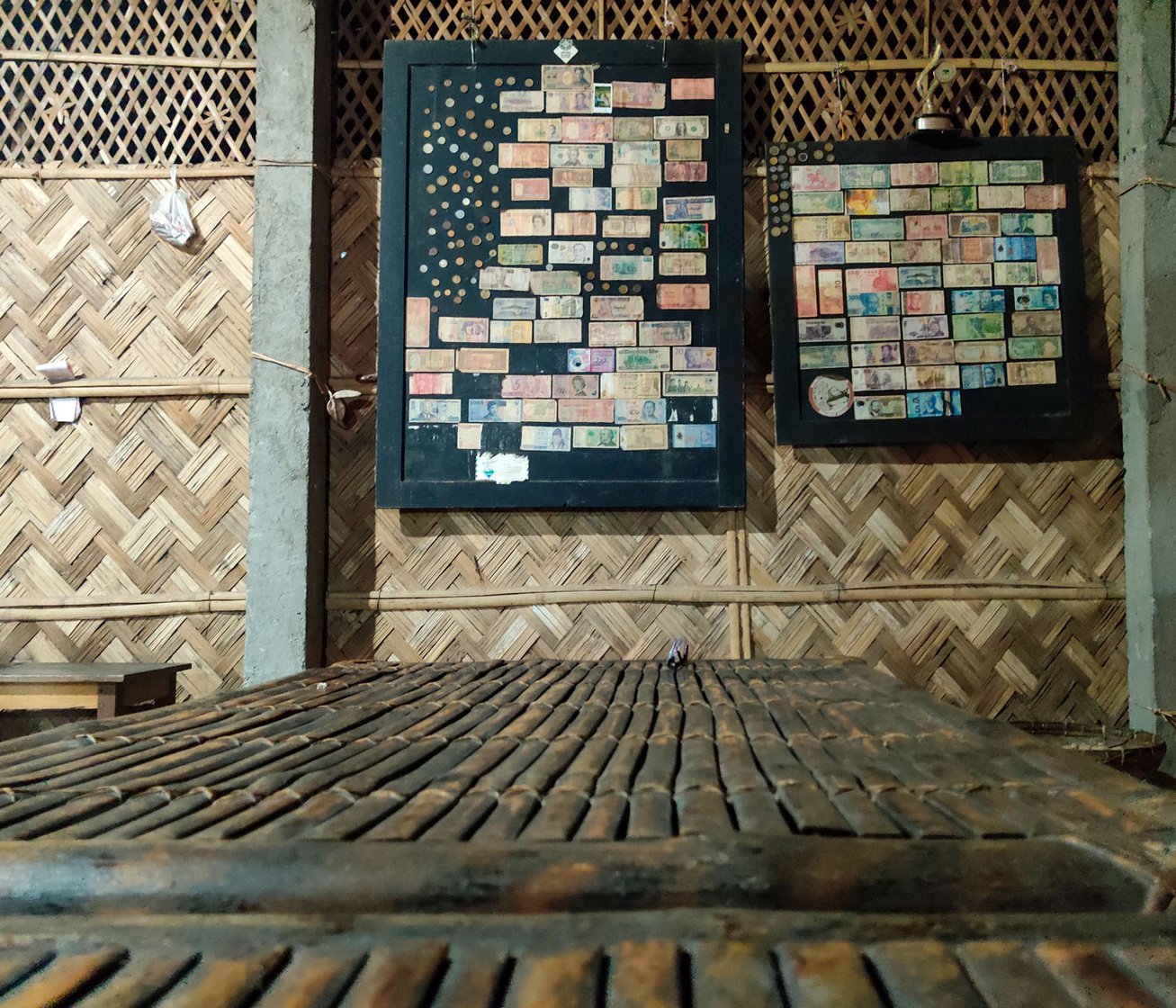 At Risong’s Kitchen, a frame on a bamboo wall holds currencies from across the world.