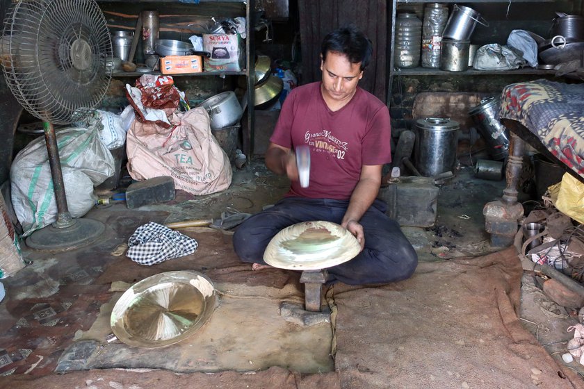 Sunil Kumar dotting a kadhai with a polished hammer