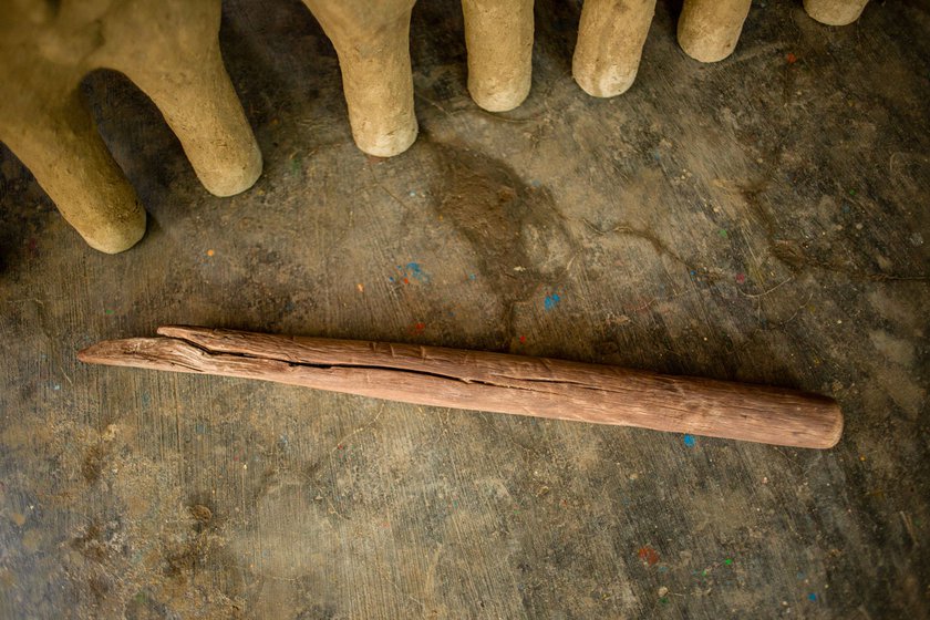 The clay is shaped into the idol's legs using a pestle (left) which has been in the family for many generations. The clay legs are kept to dry in the shade (right)