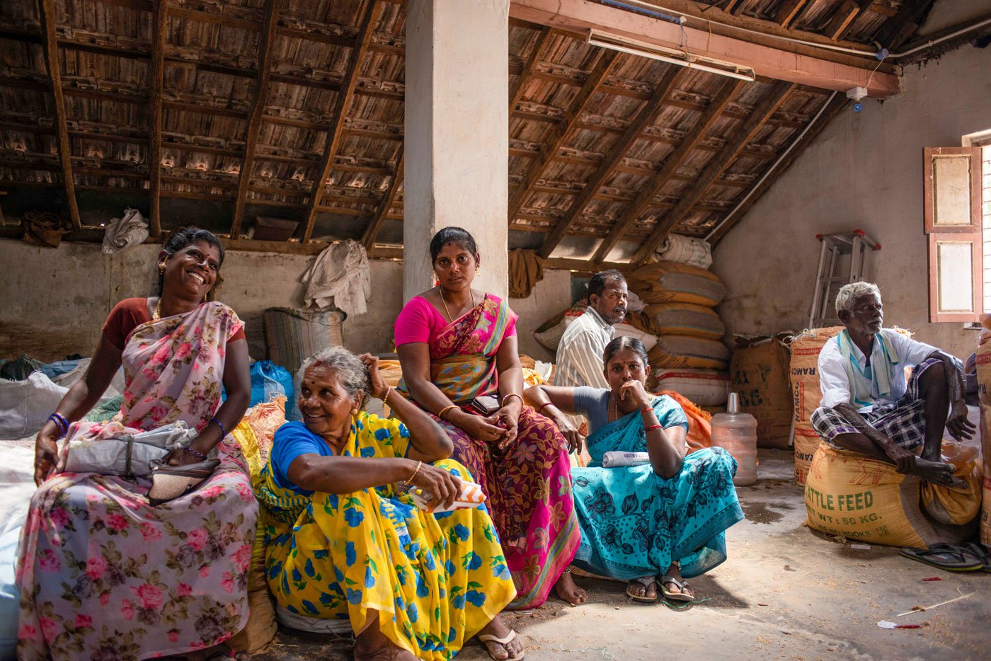Vasuki (left) and Poomayil in a yellow saree in the centre waiting for the auction with other farmers