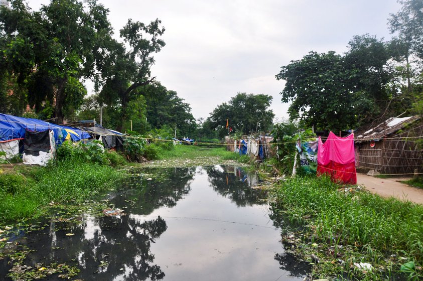 Left: During the monsoon, sometimes drain water recedes from the toilet after an entire day. Right: Residents use public taps, which are also bathing areas