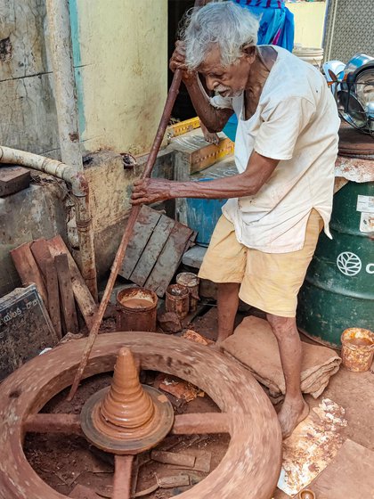 Left: The wooden potters' wheel is heavy for the 92-year-old potter to spin, so he uses a long wooden stick (right) to turn the wheel and maintain momentum