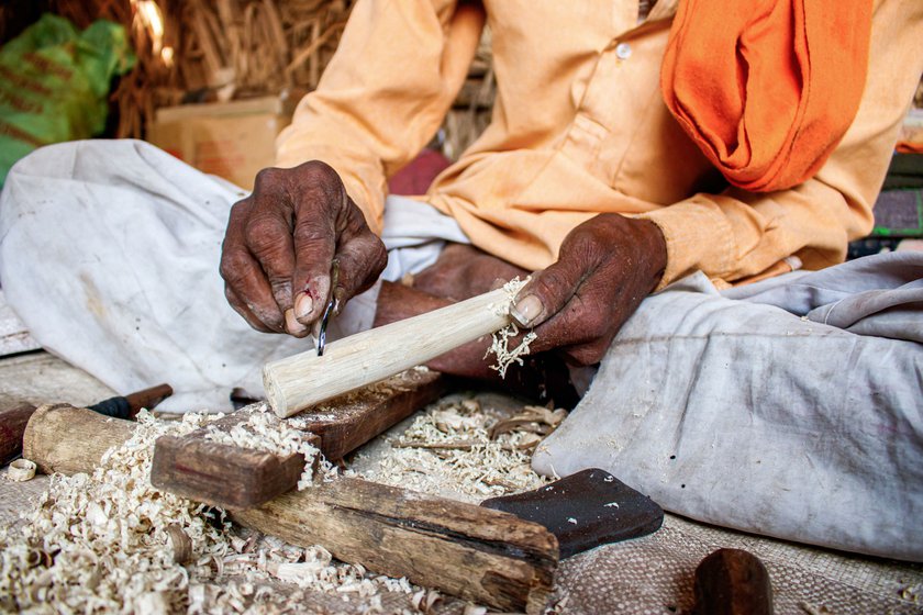 Right: Narayan uses a shard of glass to chisel the wood to achieve the required smoothness