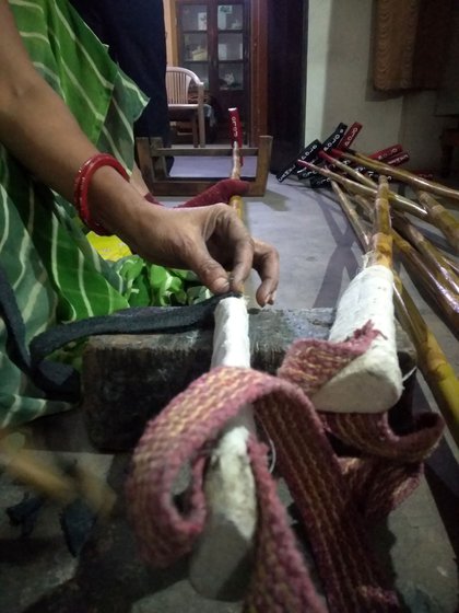 Meena binds rubber or rexine grips and fastens cotton slings onto the thicker handles using glue and nails. This grip must be visibly neat, and the sling strong, so that the stick does not slip out of the player’s grasp