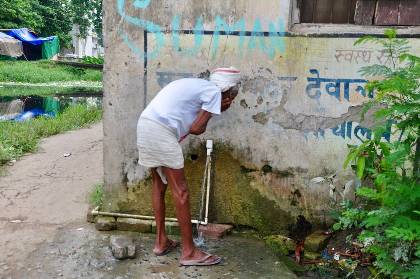 Left: During the monsoon, sometimes drain water recedes from the toilet after an entire day. Right: Residents use public taps, which are also bathing areas