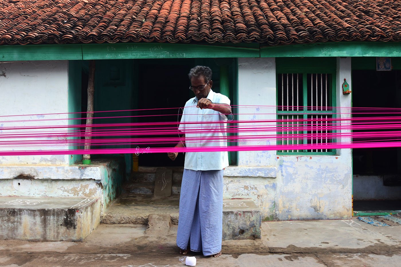 7.	M. K.  Godhandabani prepares the warp of a saree for the loom 