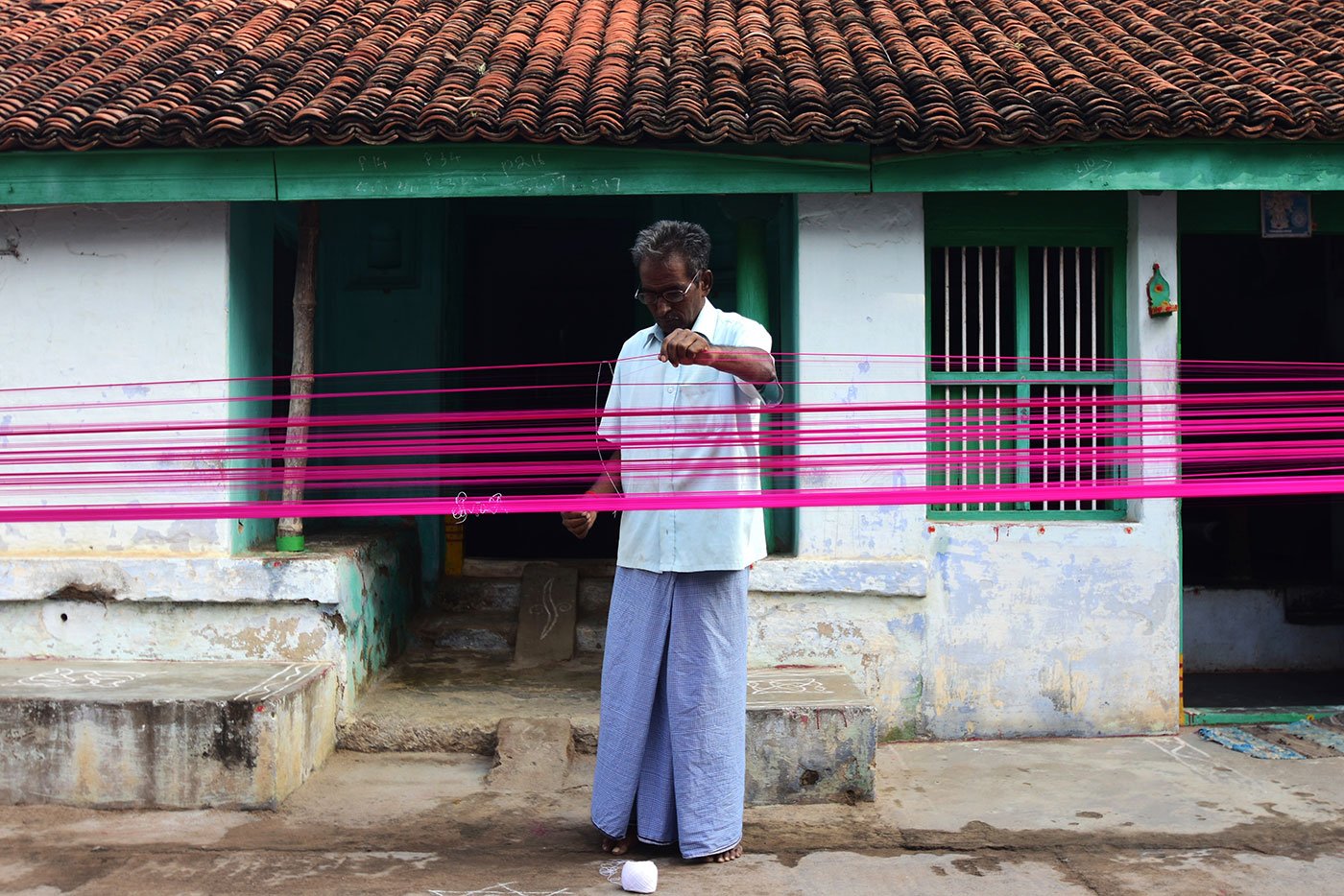 7. M. K. Godhandabani prepares the warp of a saree for the loom