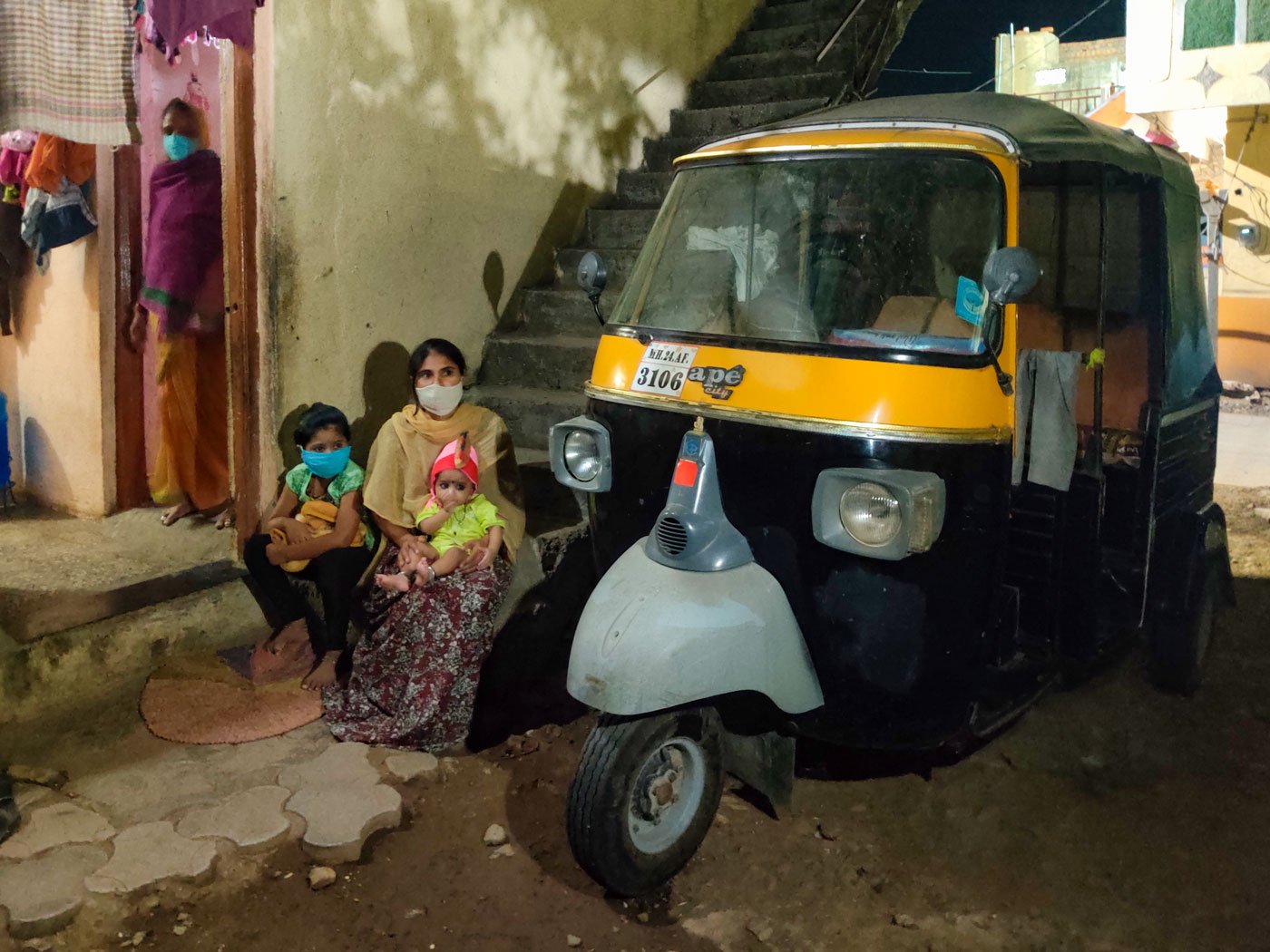 Ragini Phadke with her children outside their one-room home in Parli. The autorickshaw is the family's only source of income