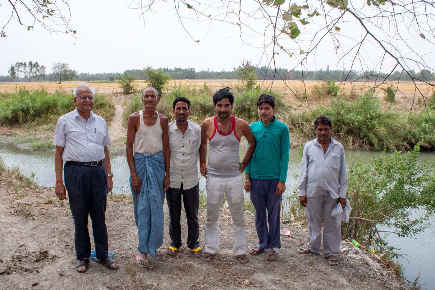 Surendra Nath Awasthi standing with villagers next to the Sai river
