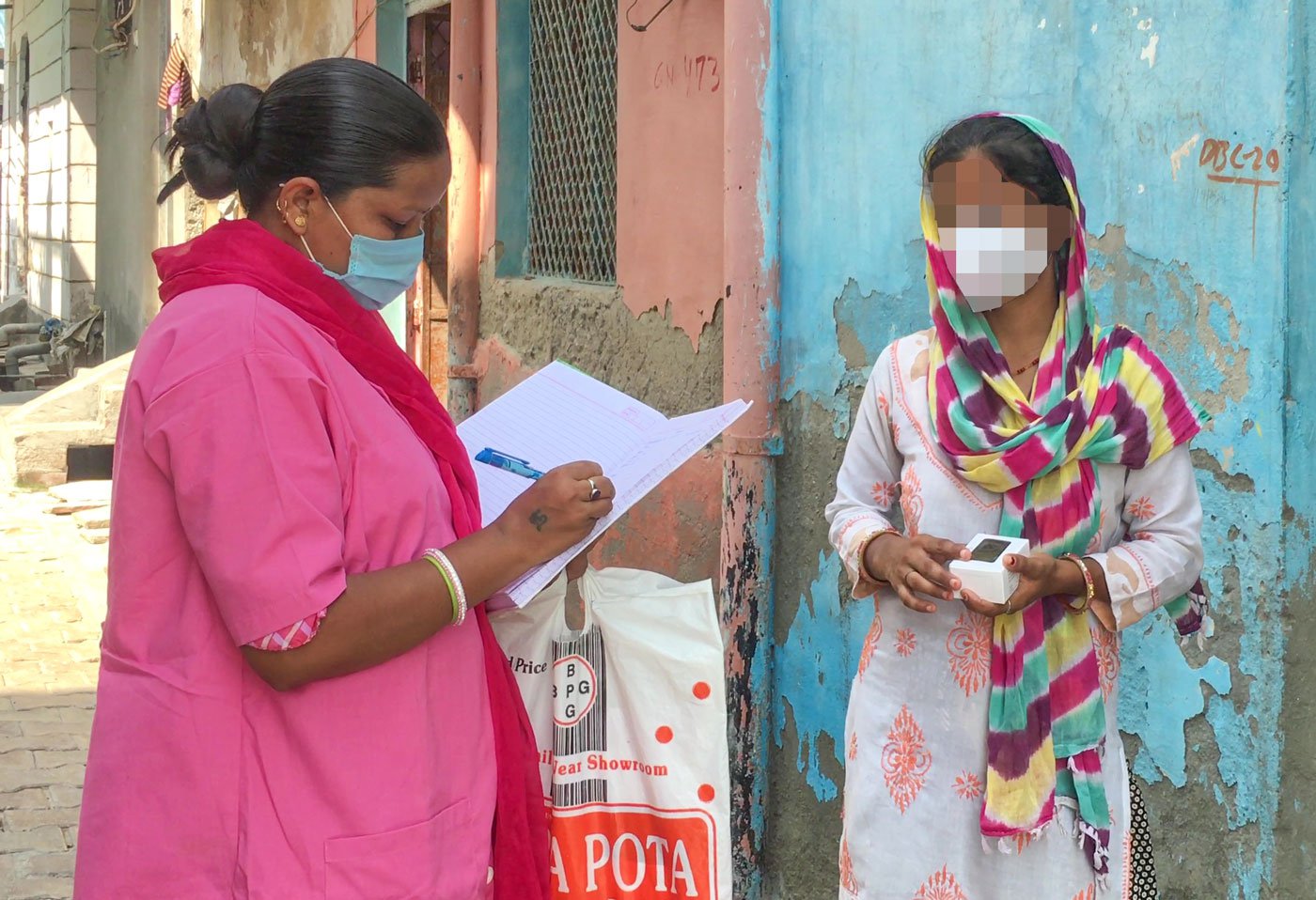 'We hear many women complaining about copper-T', says ASHA worker Sushila Devi; here she is checking Deepa's oxygen reading weeks after she tested positive for Covid-19 while still enduring the discomfort of the copper-T