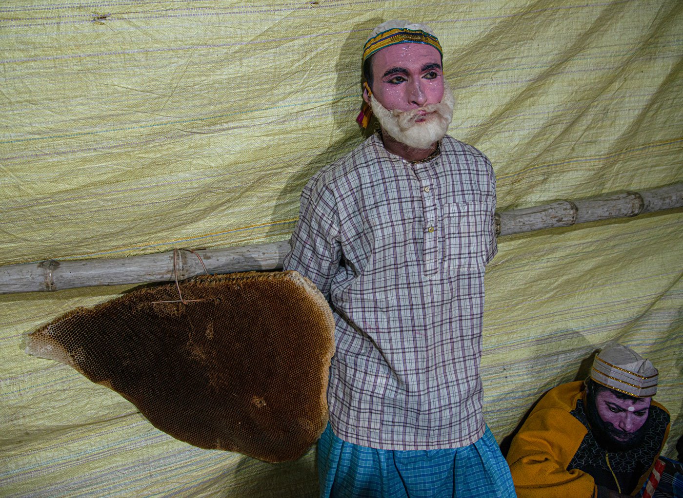 Banamali Byapari, a popular pala gaan artist of the Sundarbans, stands next to a honeycomb which is a prop for the show tonight