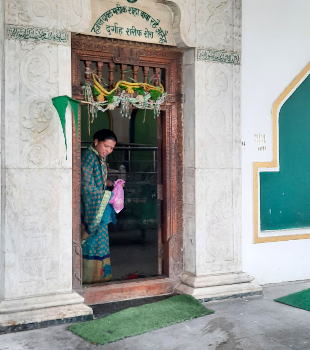 Left: A woman devotee at Dawal Malik dargah in Shera coming out after offering her prayers at the mazar .
