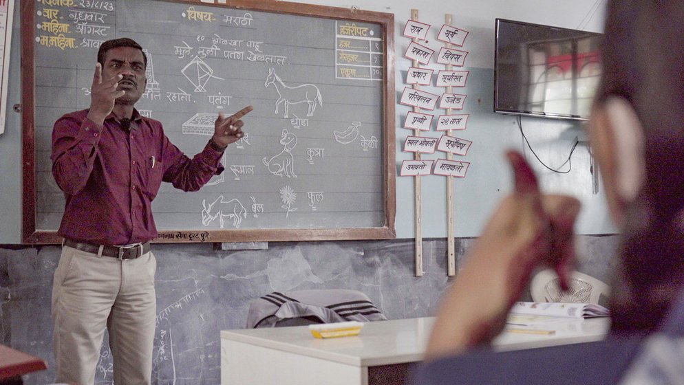 Mohan Kanekar (left) is an experienced special teacher at Dhayari School for the Hearing Impaired. He is teaching Marathi words to Class 4. ‘You have to be good at drawing if you want to teach these students,’ he says. A group of girls (right) in his class following the signs and speech of their teacher