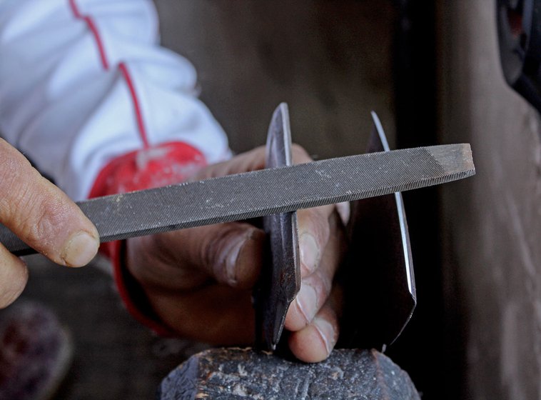 Left: Nazir sharpens his wouch using a file, which does an imperfect job.