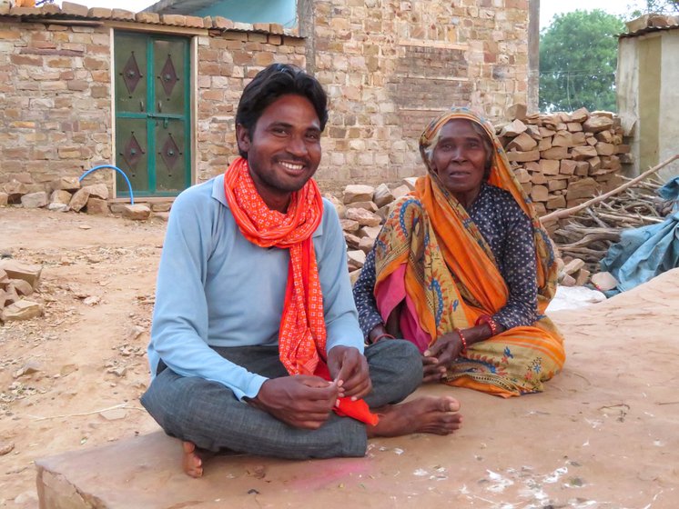 Kedar Adivasi and his mother, Kungai Adivasi, outside their home in Aharwani, where displaced Sahariyas settled.