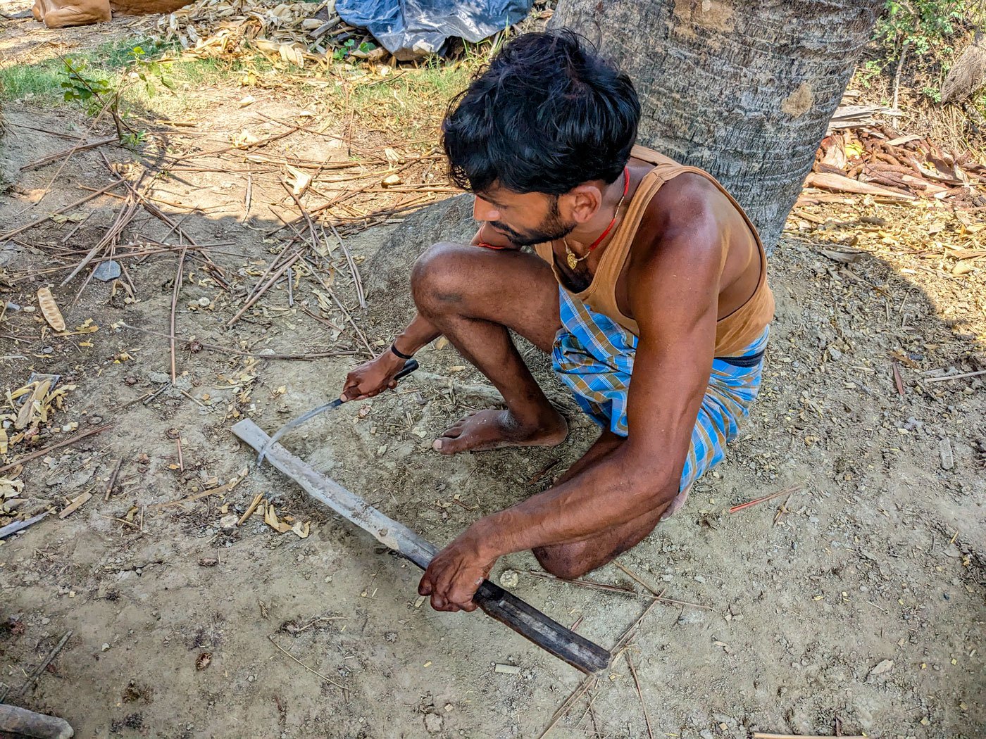 Left: Ajay sharpening the sickle with which he carves incisions. Right: Before his morning shift ends and the afternoon sun is glaring, Ajay will have climbed close to five palm trees