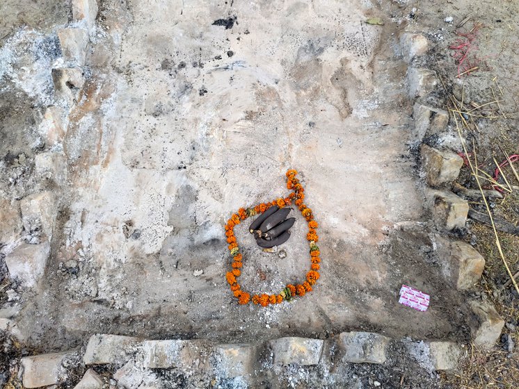 Left: The large mural at the entrance of Nigam Bodh Ghat. Right: A garland of marigold flowers and dried bananas left on the ashes after cremation