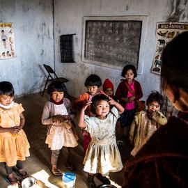 The teacher asks the children to recite a rhyme; Kynja leads the group