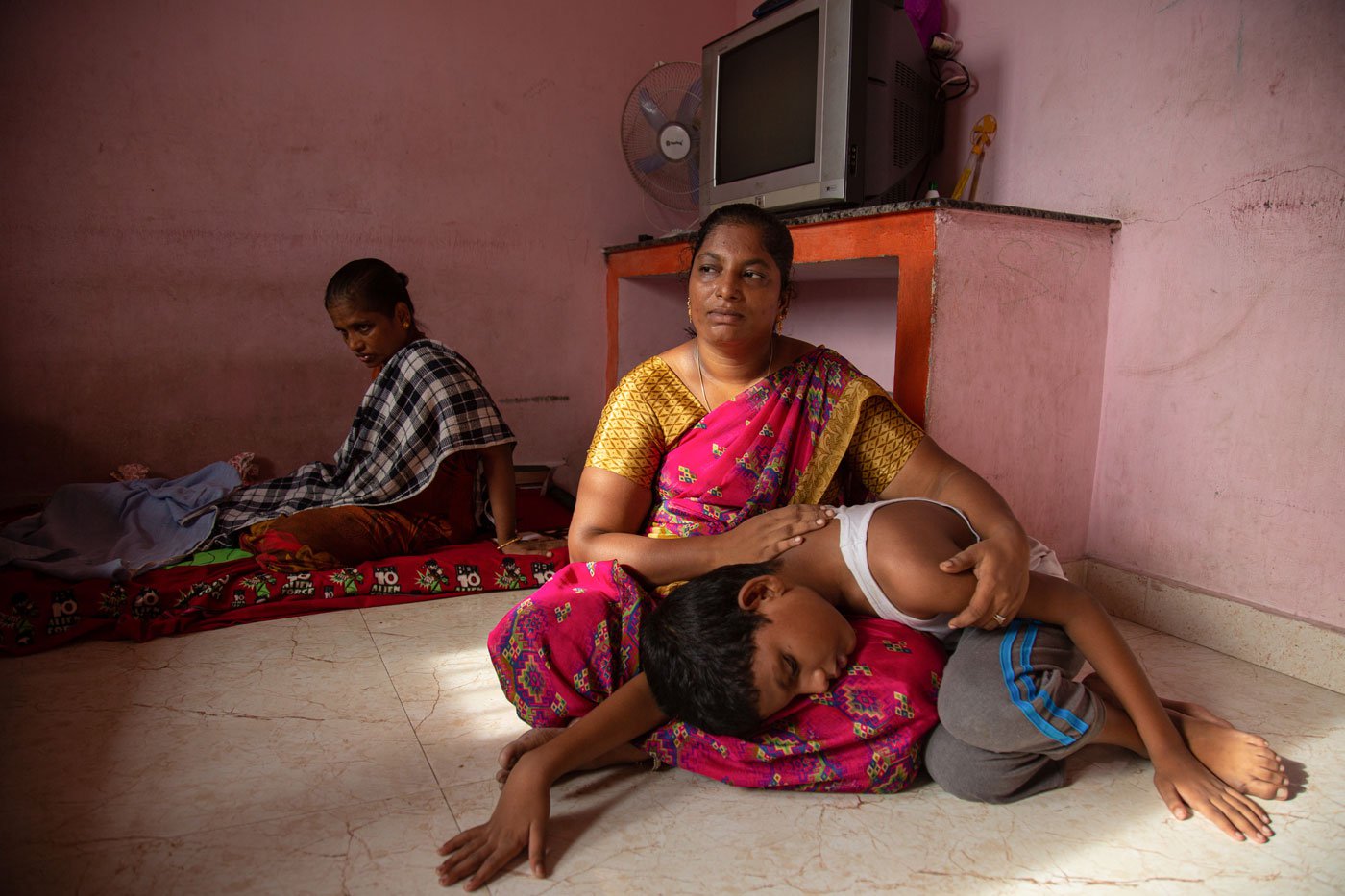 Saranya with her son Manase on her lap. 'My second son [Manase] won't eat if I am not there'
