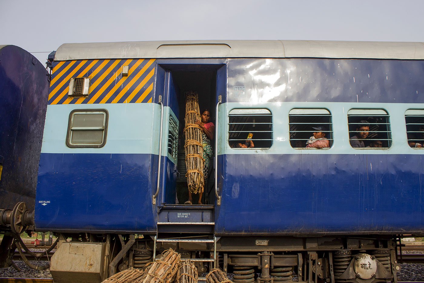 A woman unloads the firewood as the train stops at Jasra