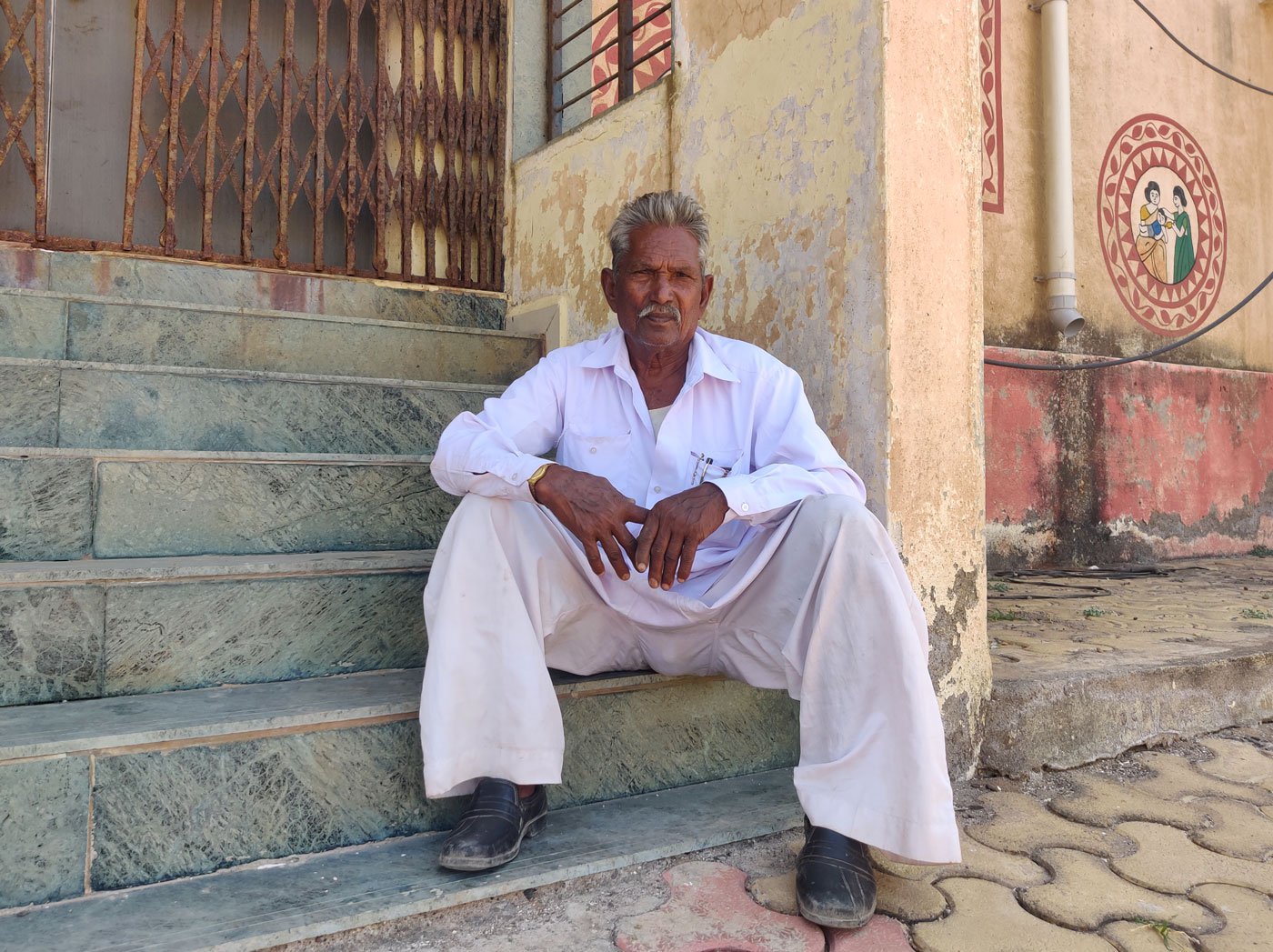 Kanabhai Baladhiya outside a Primary Health Centre in Shiyal Bet. He says, 'I have to get on a boat every time I need to see a doctor'