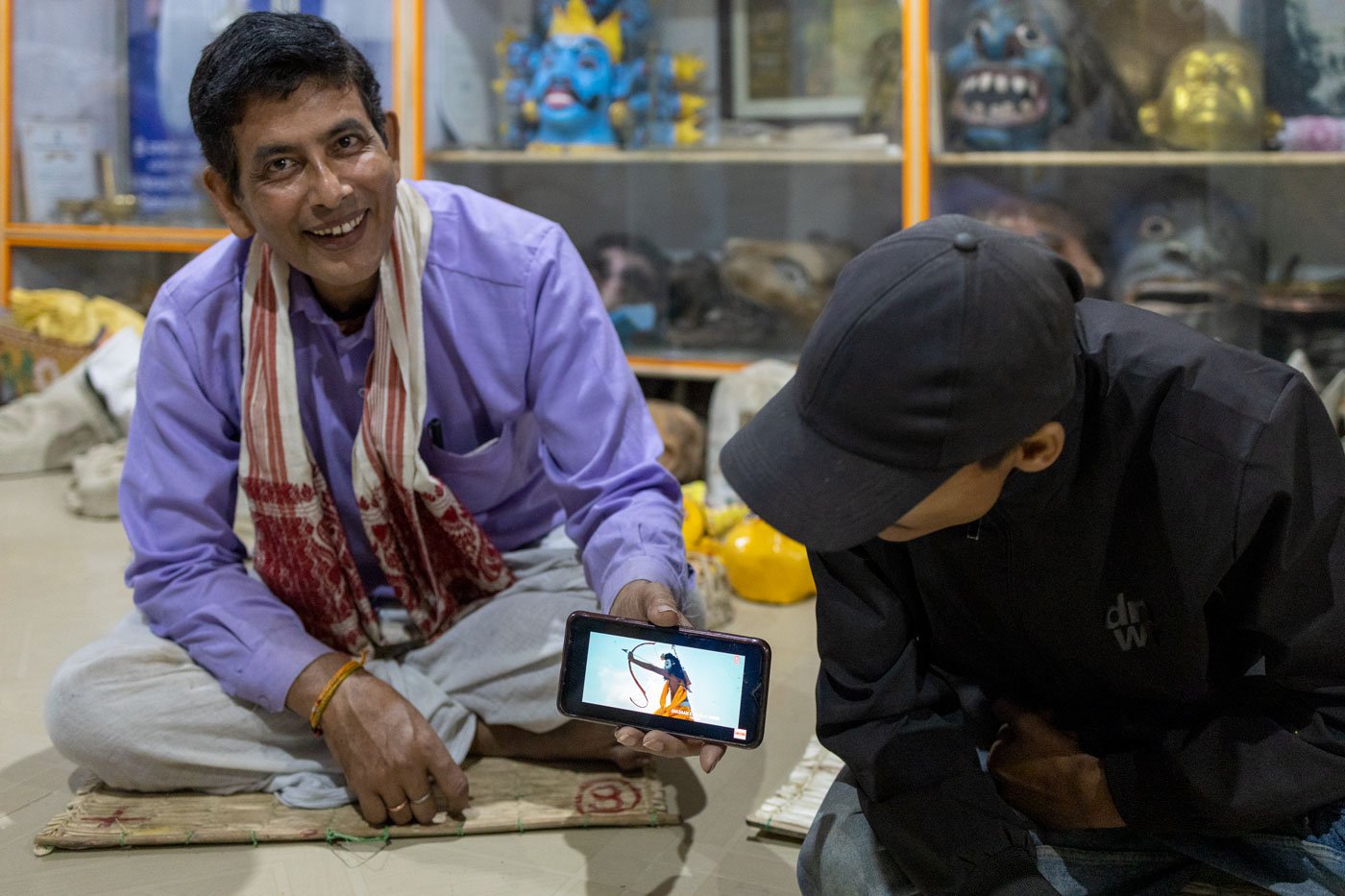 Right: Dhiren and Goutam showing a bollywood music video three mask makers from Majuli performed in. The video has got over 450 million views on Youtube