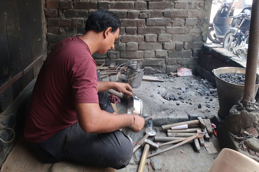 Sunil Kumar is repairing a steel chhanni (used to separate flour and bran) with kalai
