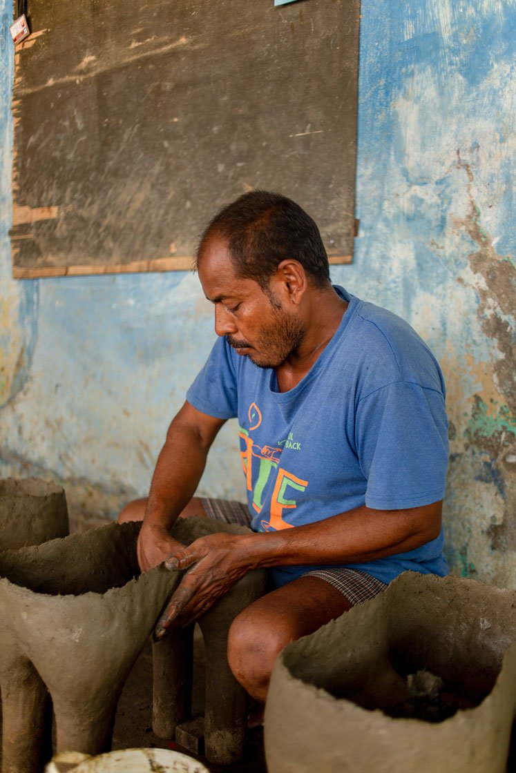 The idol maker applying another layer of the clay, hay and husk mixture to the base of the idols. ' This entire work has to be done in the shade as in in direct sunlight, the clay won’t stick, and will break away. When the idols are ready, I have to bake then in fire to get it ready'
