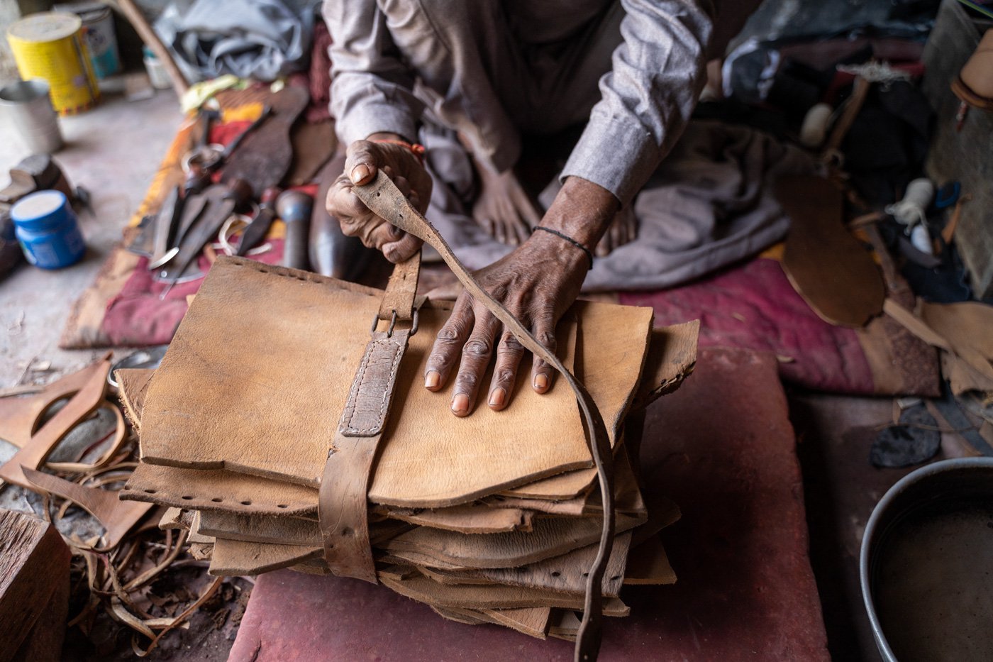 Hans Raj opens a stack of thick leather pieces that he uses to make the soles of the jutti . ‘Buffalo hide is used for the sole, and the cowhide is for the upper half of the shoes,’ he explains.