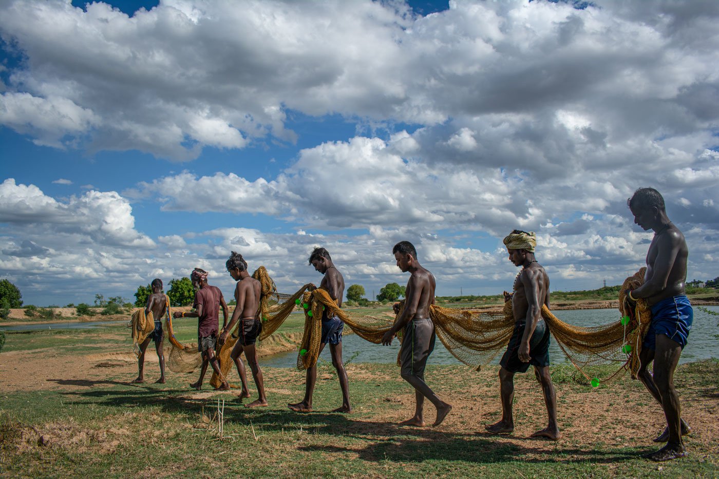 Fishermen move around the big lake in Jawaharlalpuram in Madurai to increase the catch