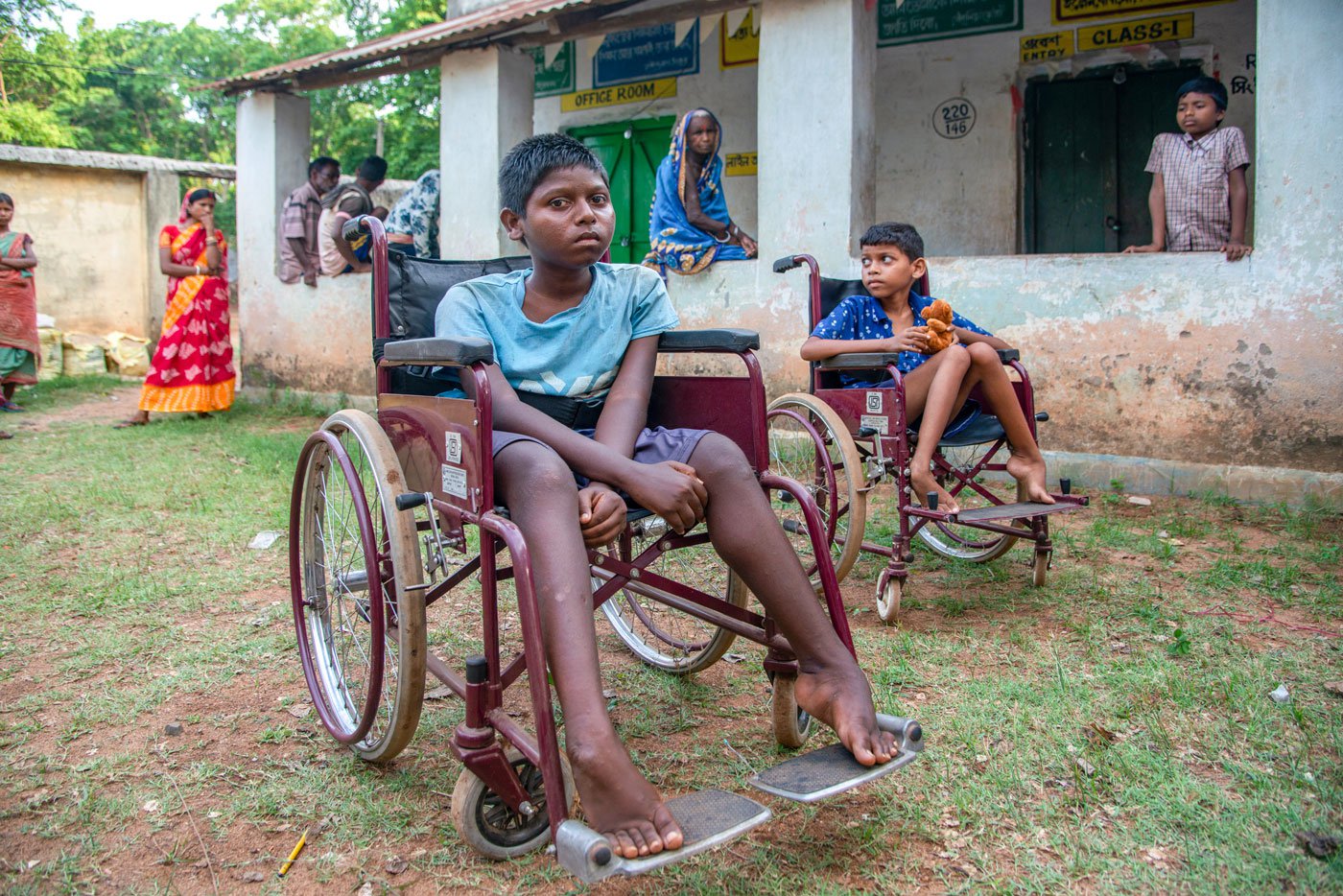 Parameswar Besra and Maheswar Beshra from Singdhui are in wheelchairs. The brothers were born healthy but lost their ability to walk over time. They could not get the help they needed as healthcare facilities are far, and the family's precarious financial condition did not allow it