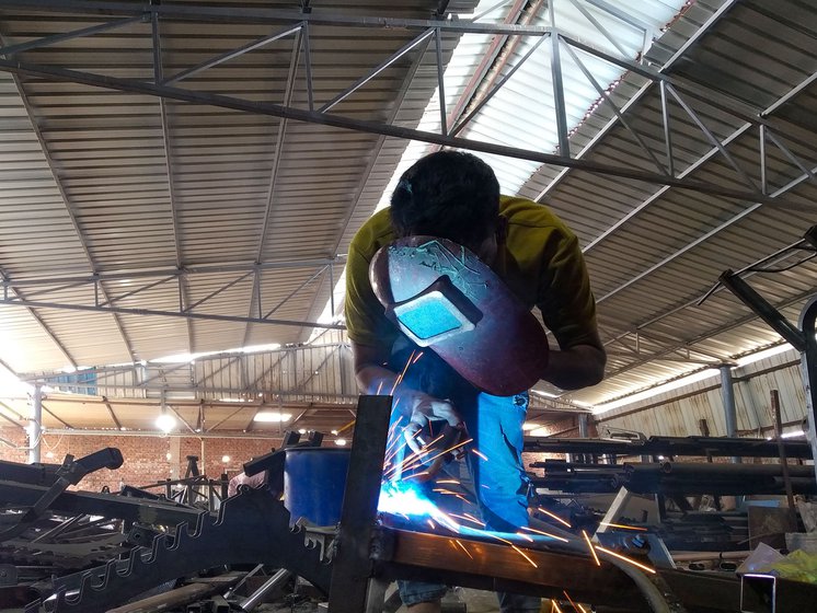 Left: Ibad Salmani  uses a hand shield while strengthening the joints of gym equipment parts with a Metal Inert Gas (MIG) welder.