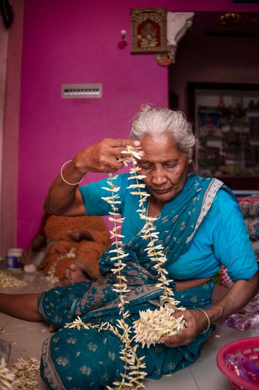 Seated in her house (left) behind Thovalai market, expert stringer Meena threads (right) jasmine buds of the jathi malli variety. Now 80, she has been doing this job for decades and earns a paltry sum for her skills