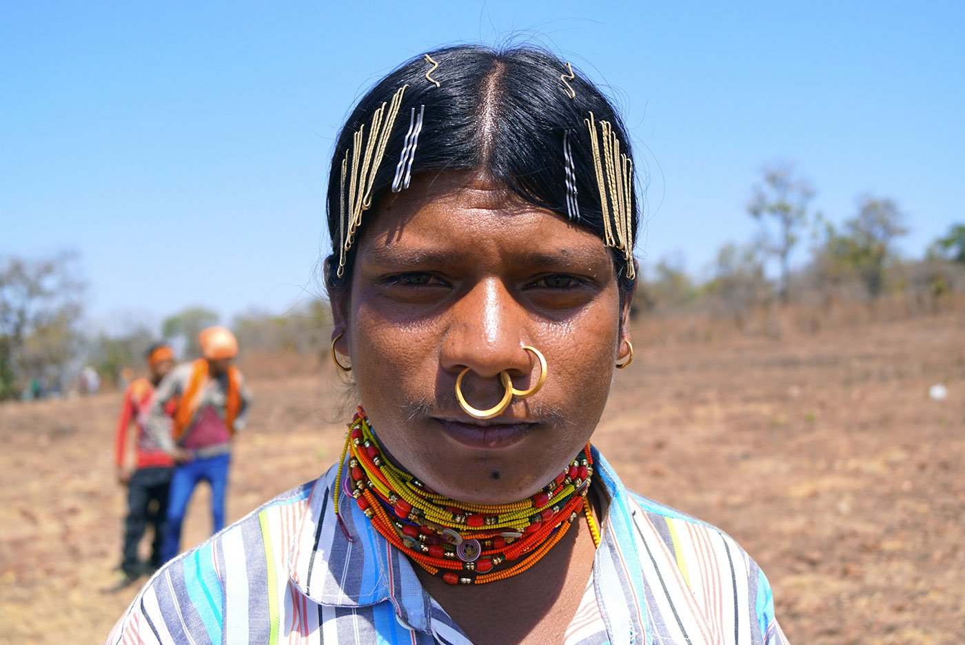 A tribal man wearing necklaces and a nose ring