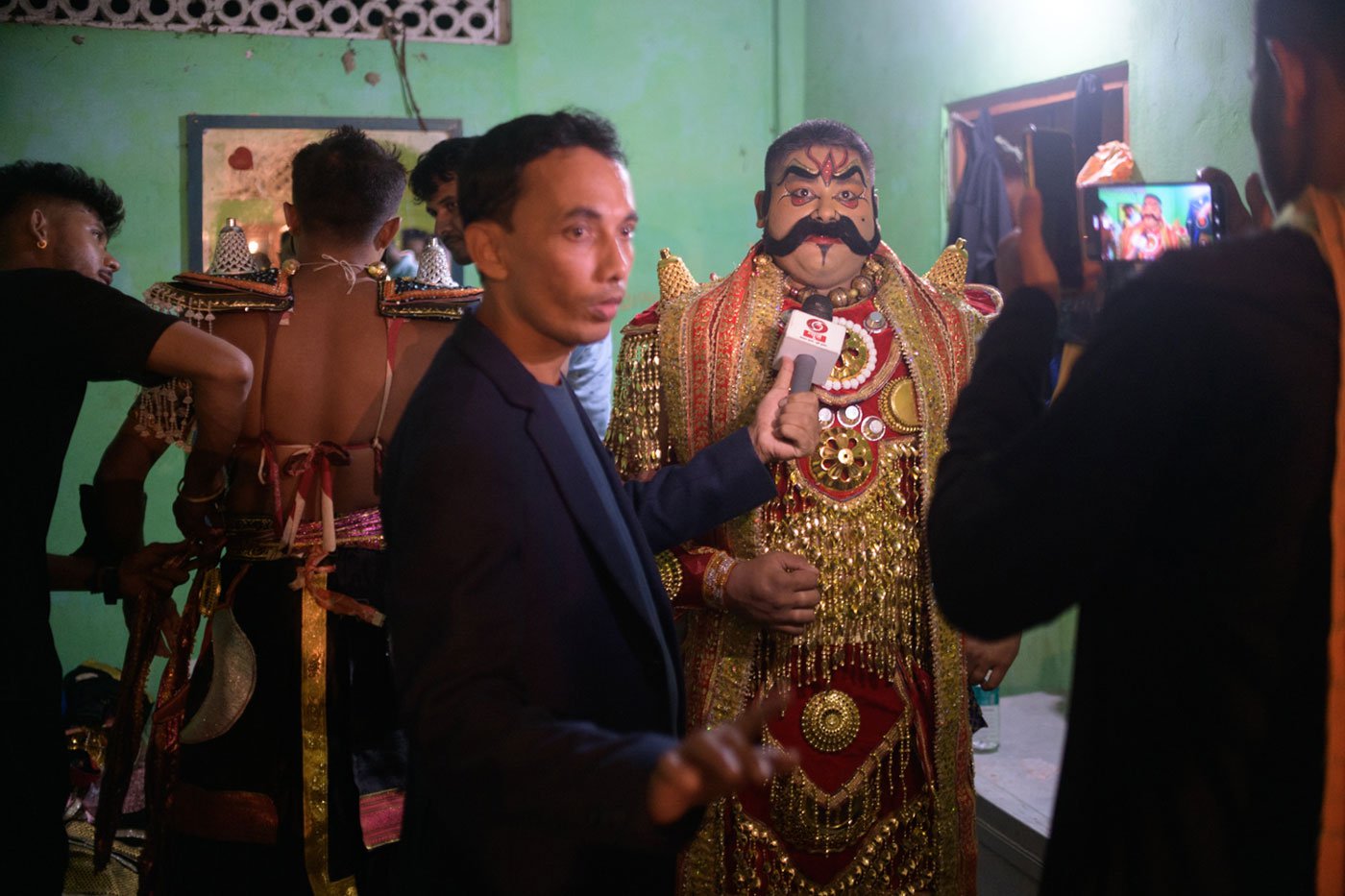 Reporters interviewing Mridupawan Bhuyan, who plays the role of Kansa, at the Garamur Saru Satra's festival